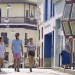 turistas pasean por calle cubana