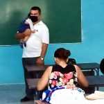 profesor carga a un niño en Cuba